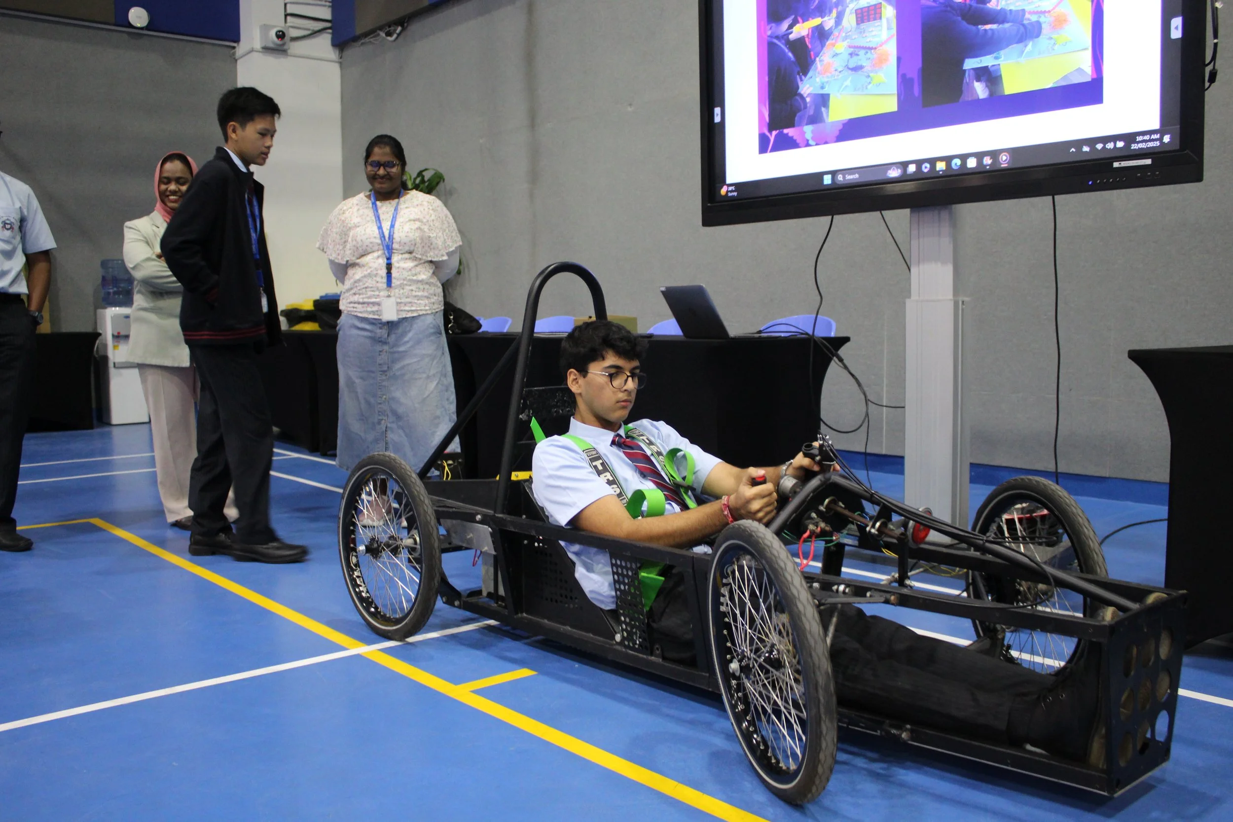 A student presenting a hand-built electric car at STEMforAll